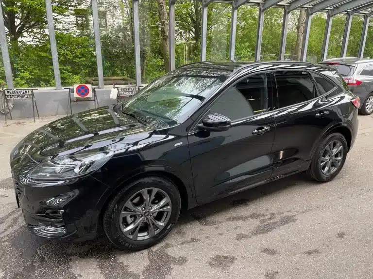 Schwarzes Auto nach professioneller Autopolitur München mit spiegelndem Lackfinish